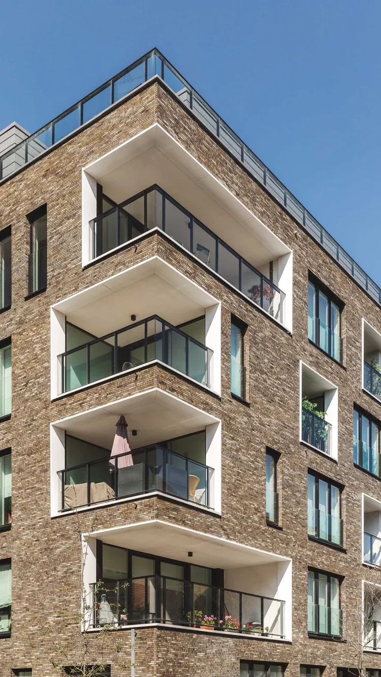 Balcons superposés au tournant d’un volume en brique