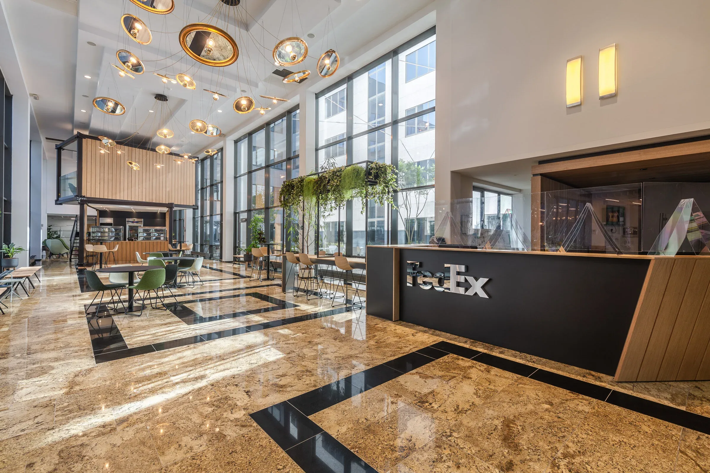 Grand espace commun FedEx avec tables et paroi signalétique