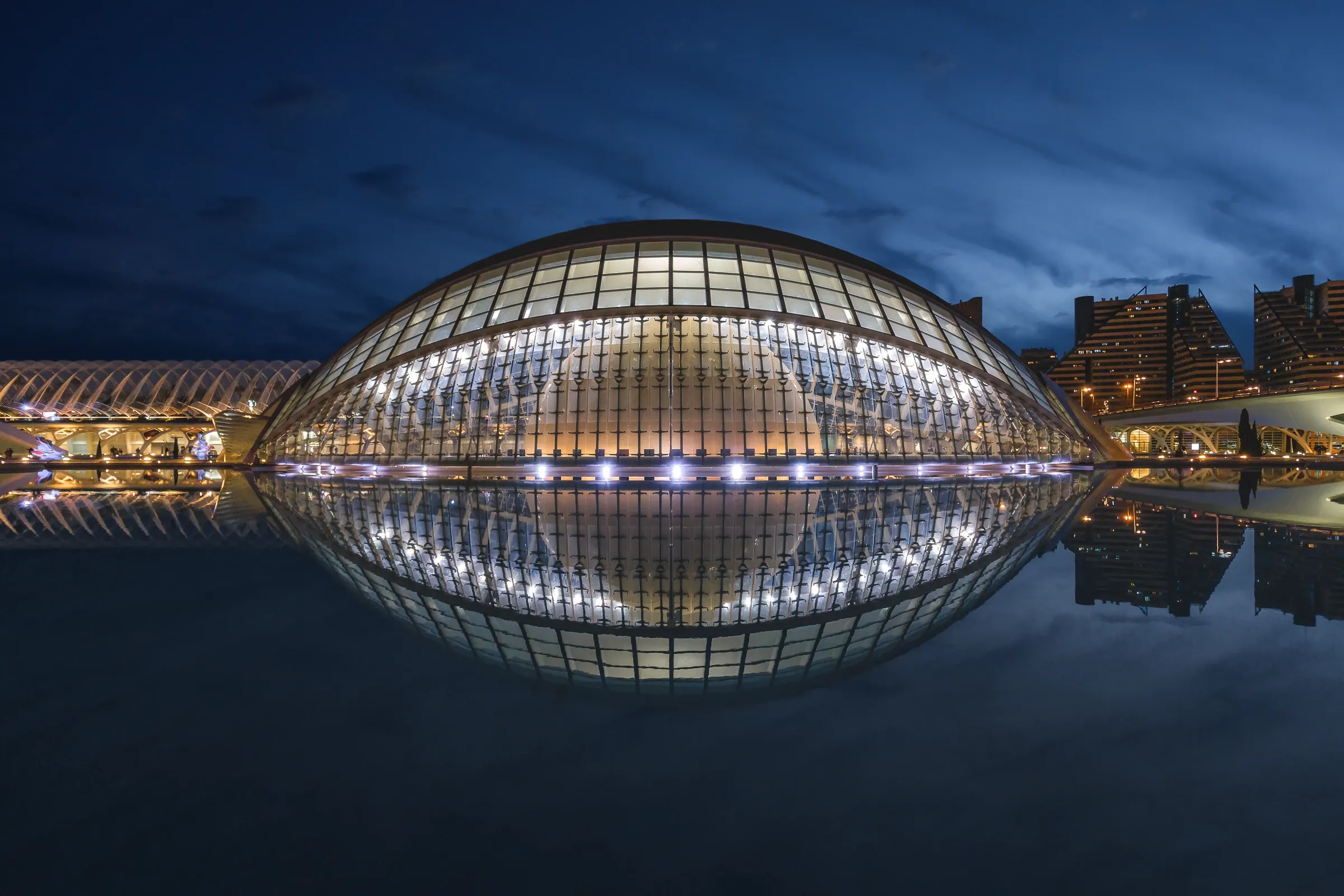 Hemispherical glazed building and its reflection at blue hour