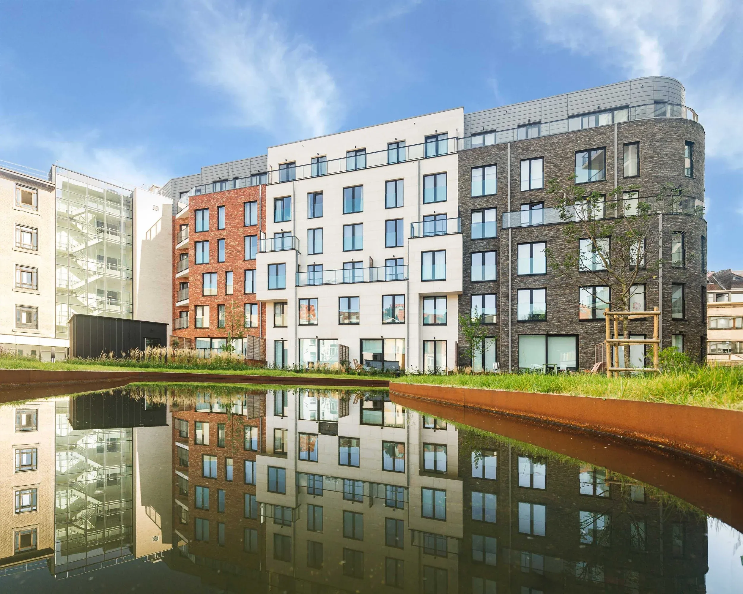 Façades de Cavell Court reflétées dans le plan d’eau du jardin