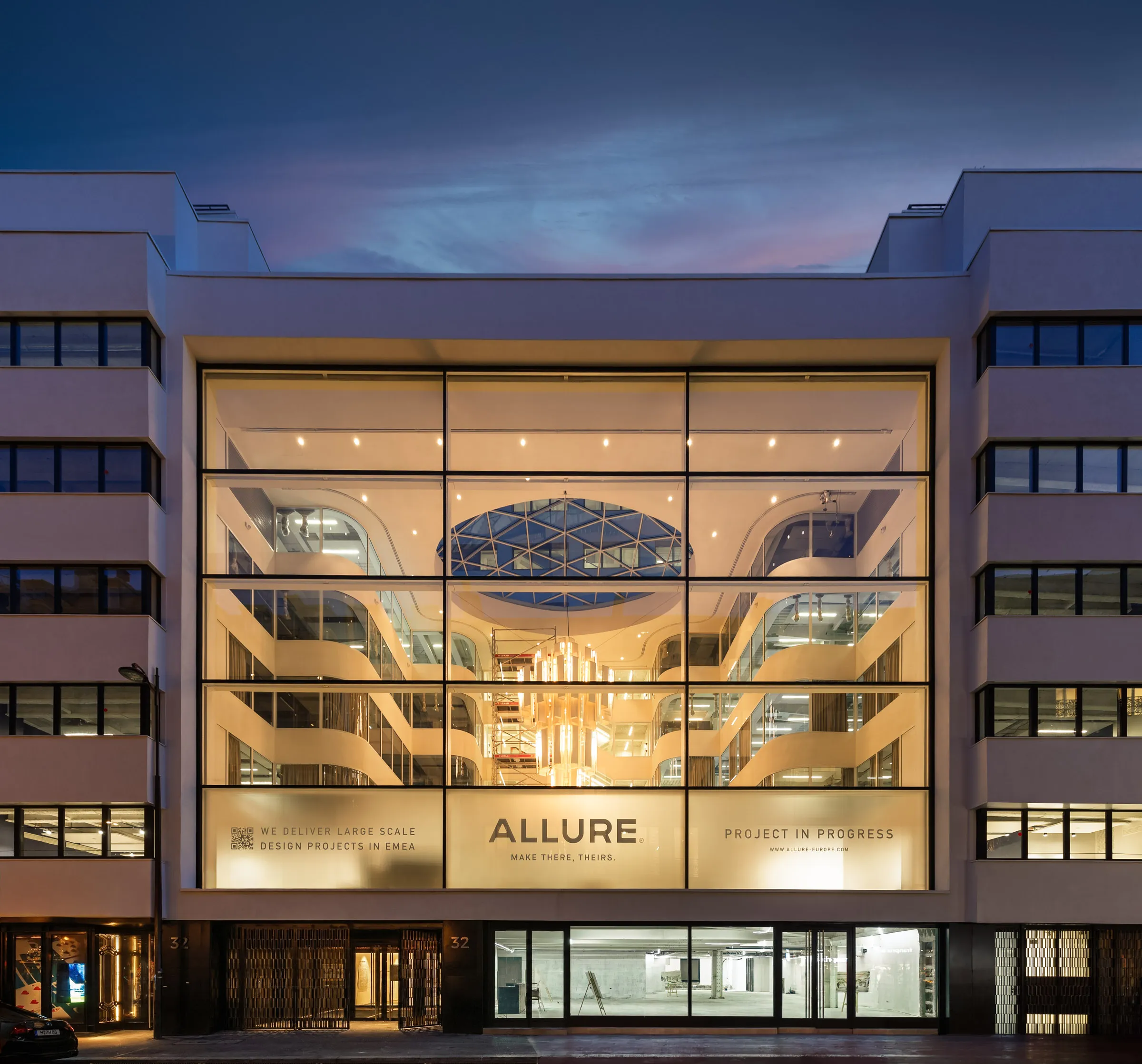 Vue frontale d Icône au crepuscule, avec la facade vitree de l atrium eclairee
