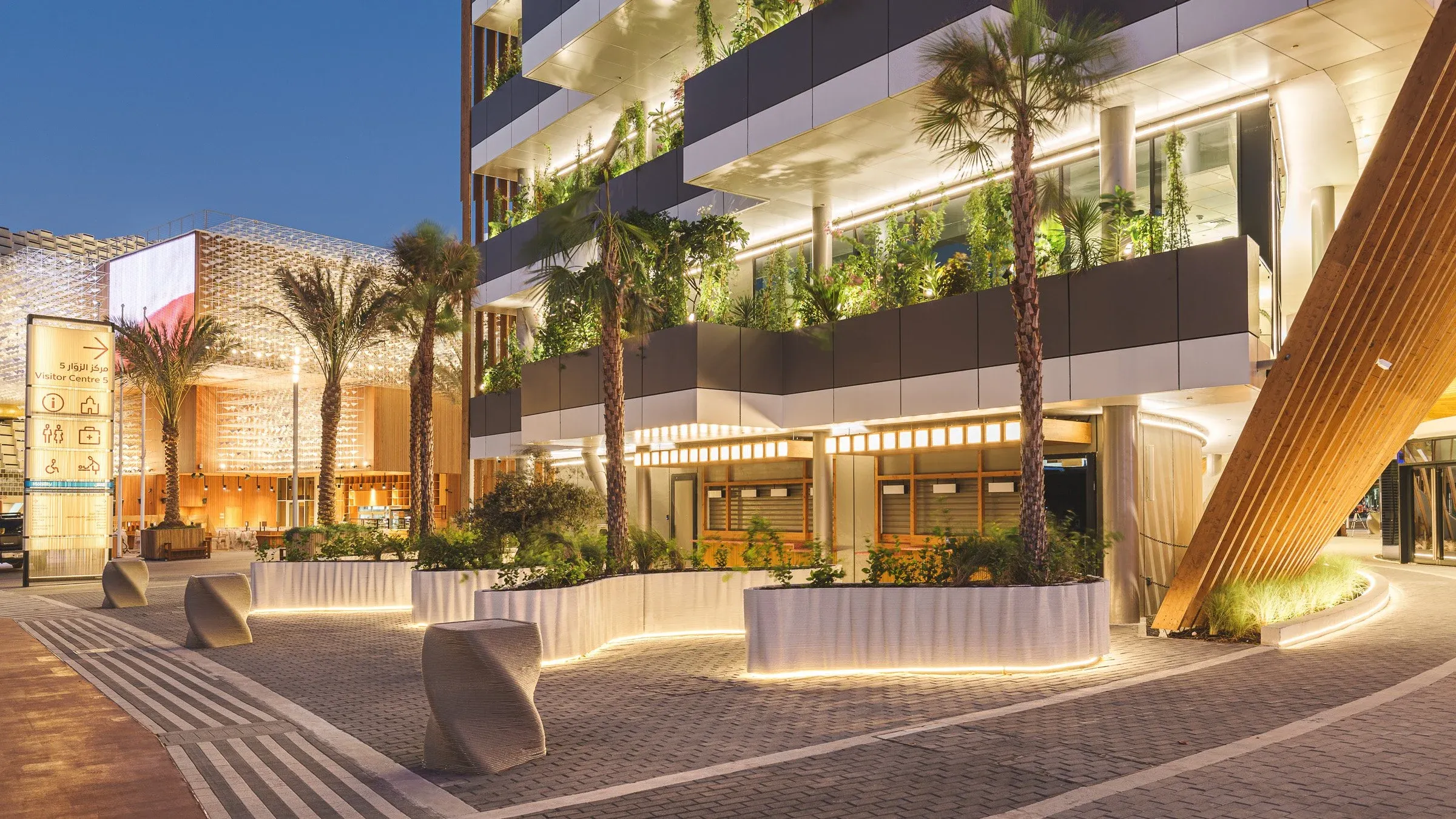 Terrasse extérieure plantée éclairée de nuit