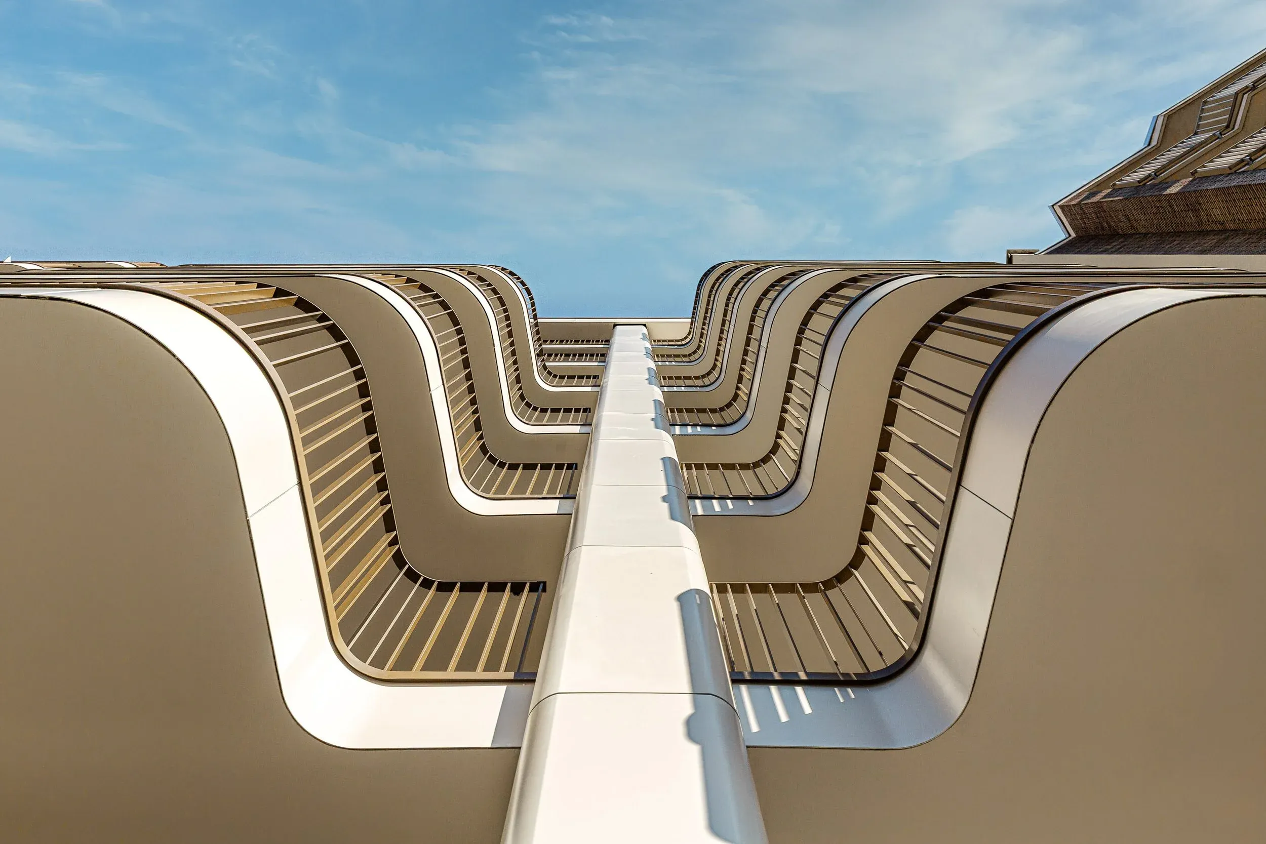 Vue ascendante à travers les sous-faces courbes des balcons superposés