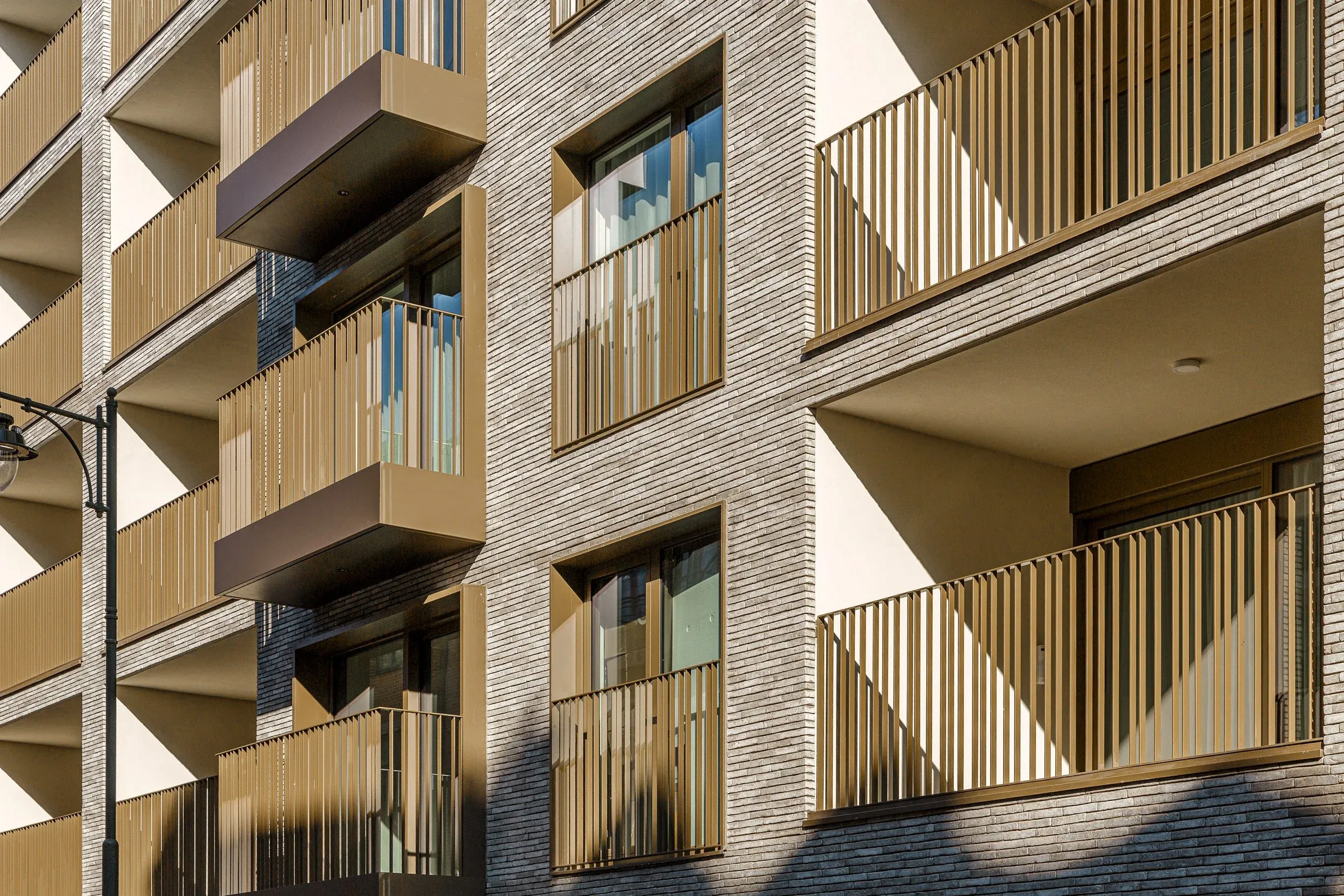 Façade en pierre claire et garde-corps de balcon couleur bronze