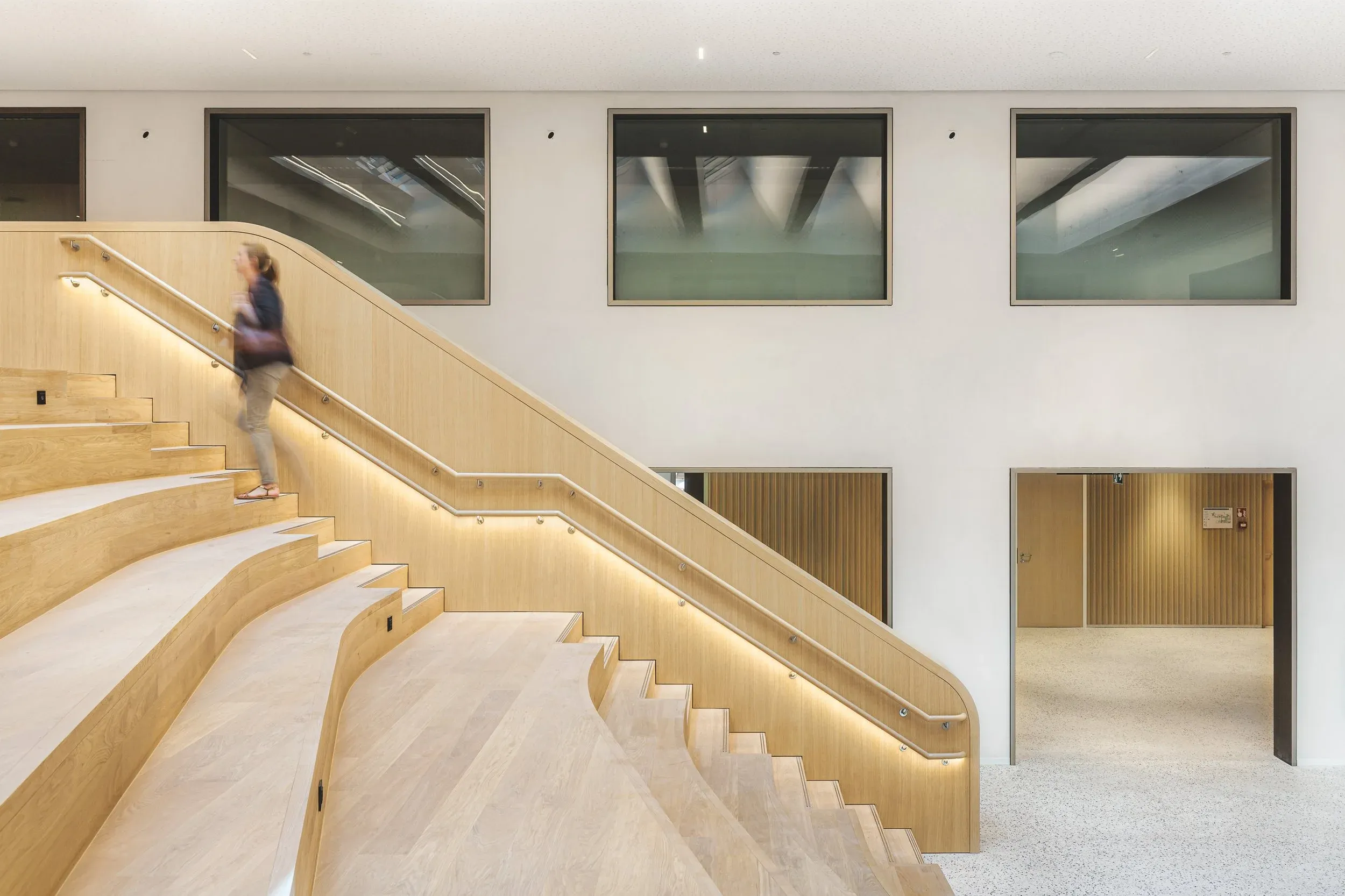 Gradin-escalier en bois avec un visiteur traversant le centre du Parlement européen
