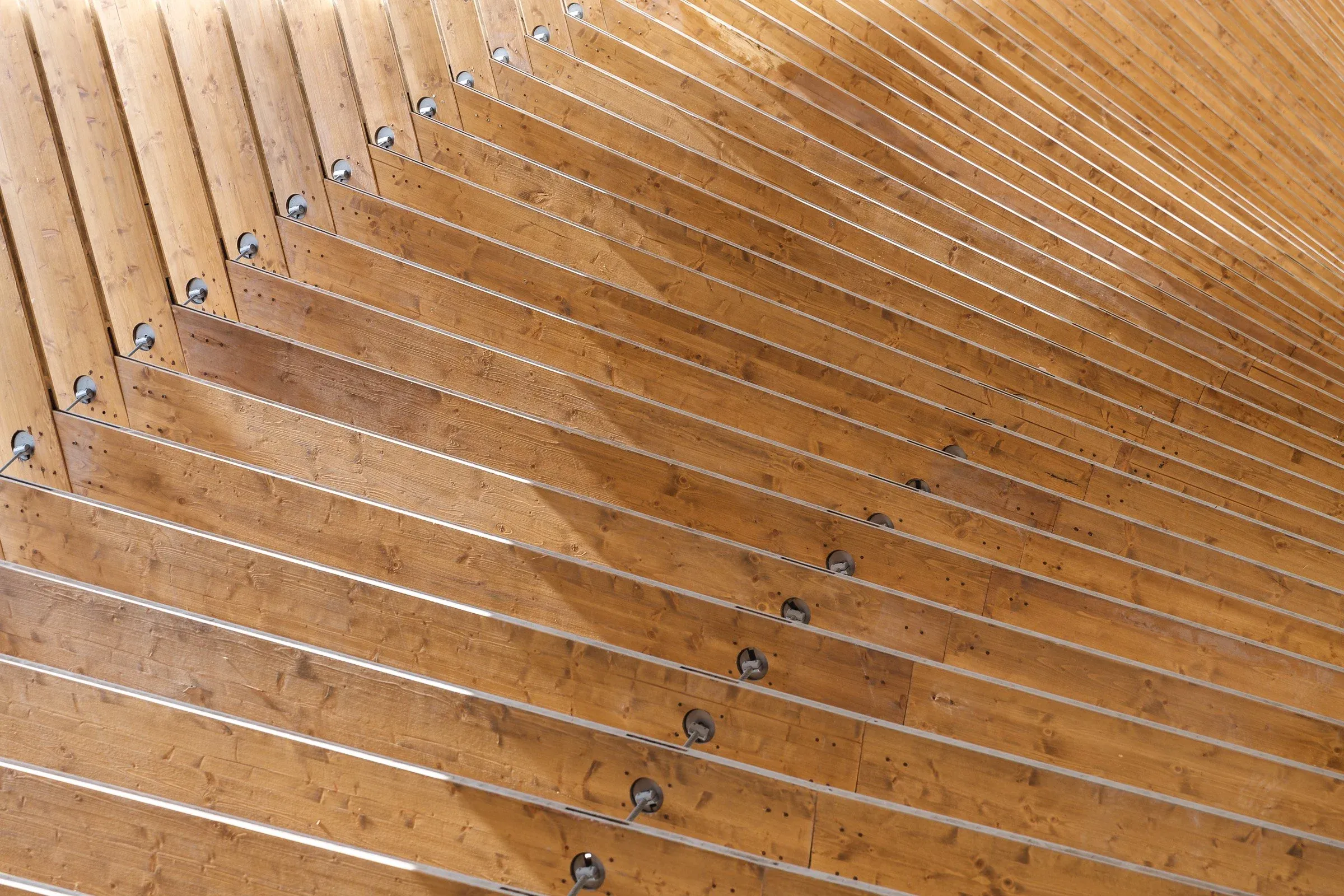 Vue rapprochée de la voûte en bois stratifiée sous le pavillon