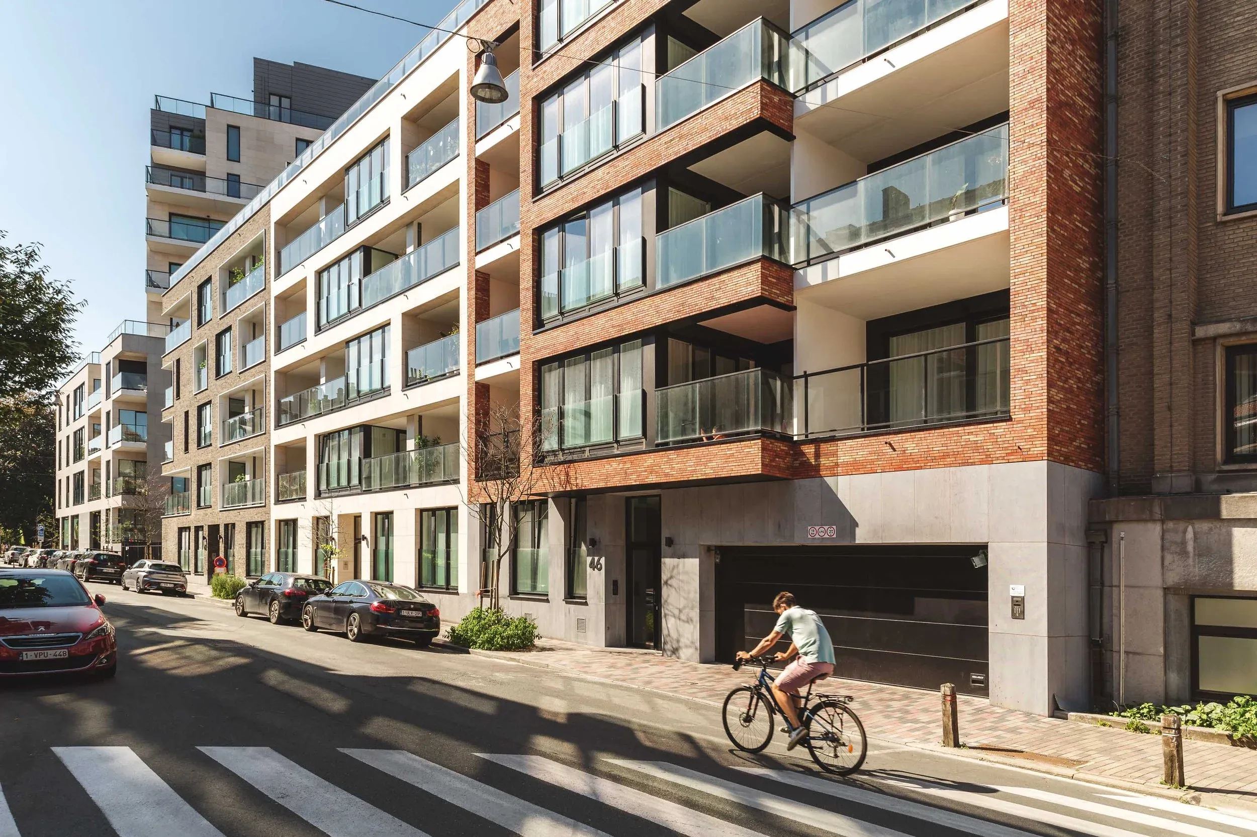 Angle urbain de Cavell Court avec un cycliste devant la façade en brique